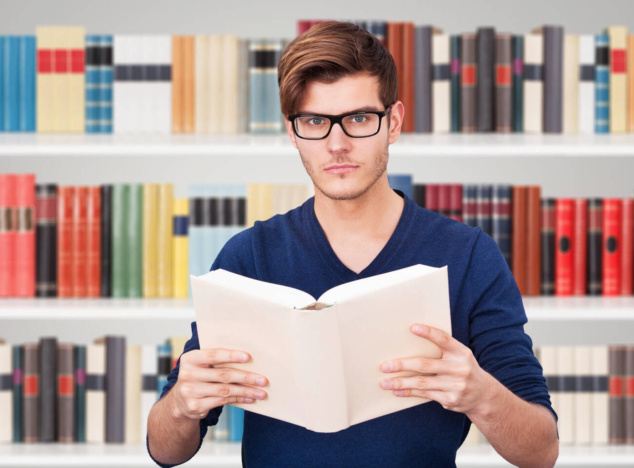 Stock image of a total dork holding a big book with both hands